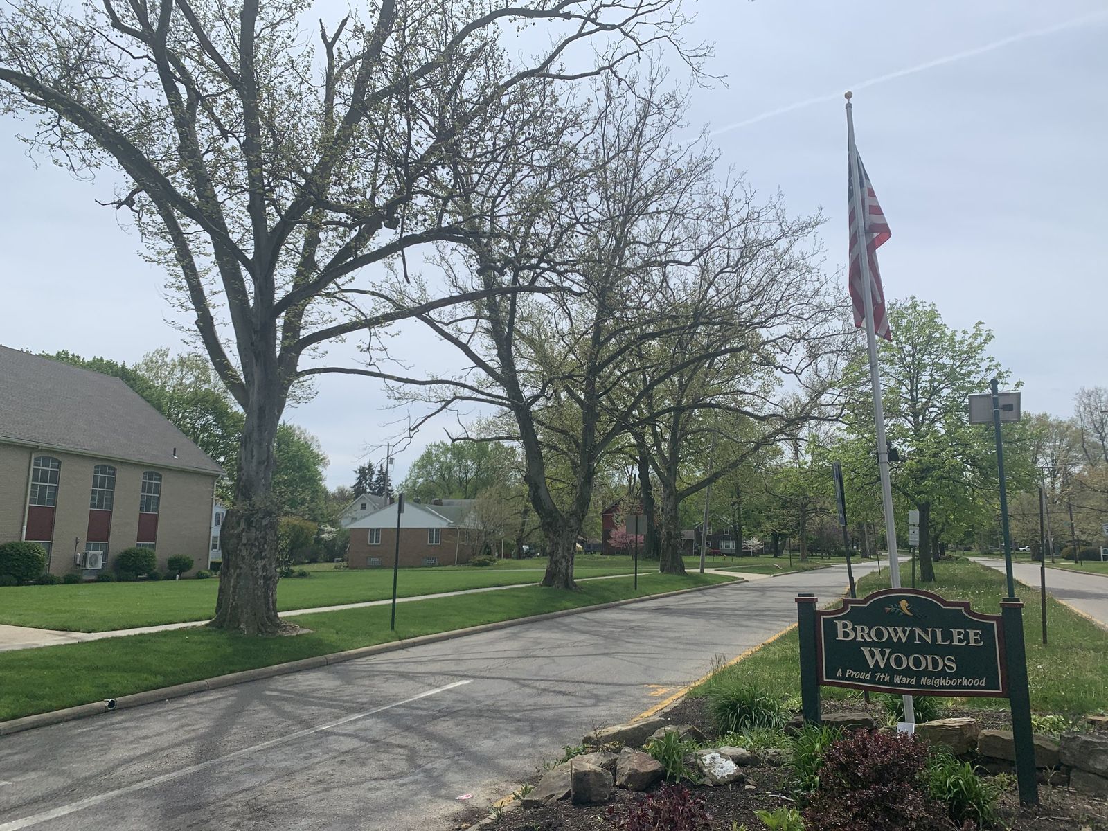 Sheridan Road in the Brownlee Woods neighborhood of Youngstown, with a neighborhood sign and an American flag.